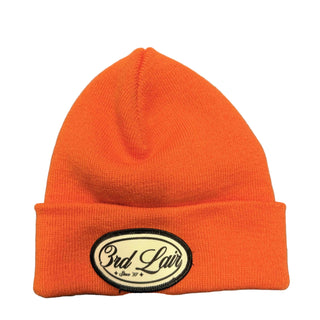 Orange beanie with a logo on a gray surface